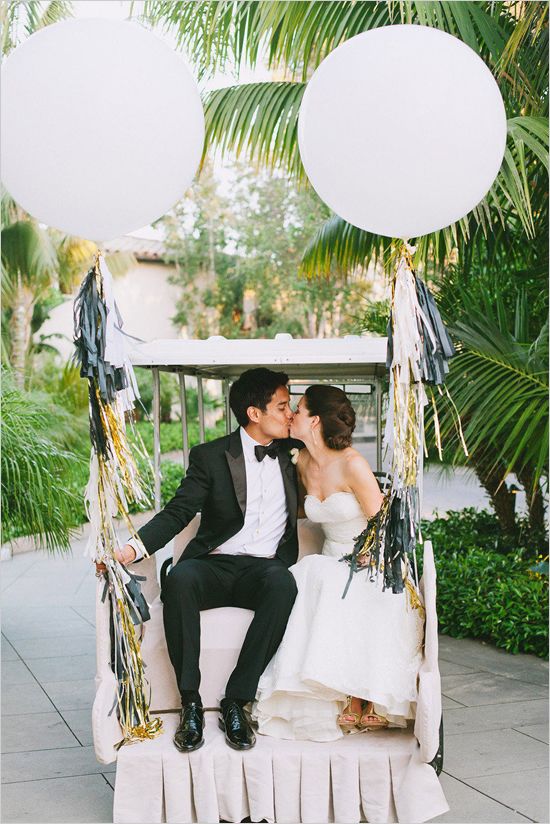 Bride and Groom kissing while holding balloon