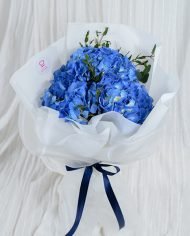 Hydrangea wrapped in white paper and tied with a ribbon